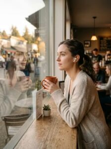 woman looking out of a cafe window not sure what to do
